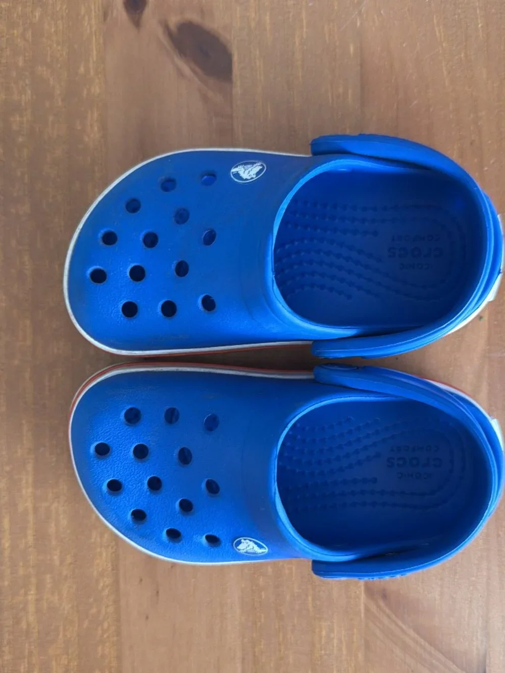 Toddler blue Crocs with red and white band